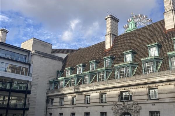 London eye peeping over the building at London County Hall